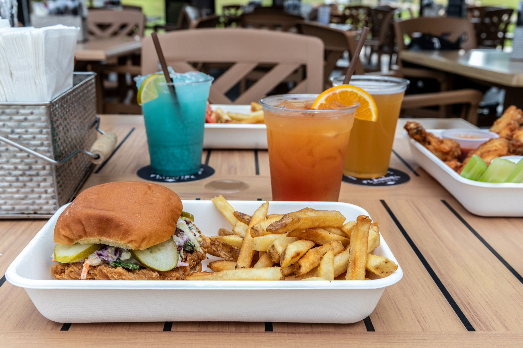 Casual fare and cocktails at Bravo Zulu Lakeside Bar. A photo of a burger and fries is at the front of the photo.